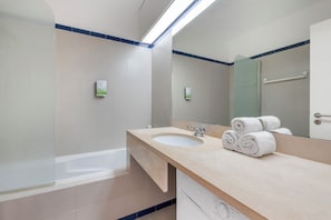 Une salle de bain moderne avec une baignoire, un lavabo et un miroir.