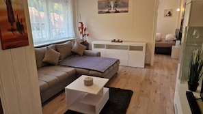 Een moderne woonkamer met een bank, een salontafel en een witte tv-meubel.
