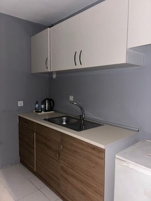 A compact kitchen with a sink, cabinets, and a countertop. - Masionette Home Village 10 (Bergheim)