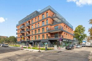 En byggnad med flera våningar och modern design, med en blandning av tegel- och glasfasader.