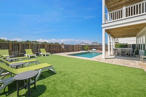A backyard with artificial grass, a pool, and outdoor furniture. - Shore Thing: Oceanside, Private Pool, Hot Tub (Corolla)