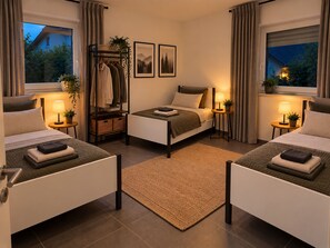 A hotel room with two beds, a wardrobe, a bedside table with a lamp, and a view of the outdoors. - Apartment 'Felix Living 11 – Lusenblick - Großzügige Wohnung für bis zu 8 Personen' (Mauth)