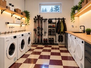 Pesuhuoneessa on useita pesukoneita, pyykiteline ja ikkuna, josta avautuu näkymä puihin.