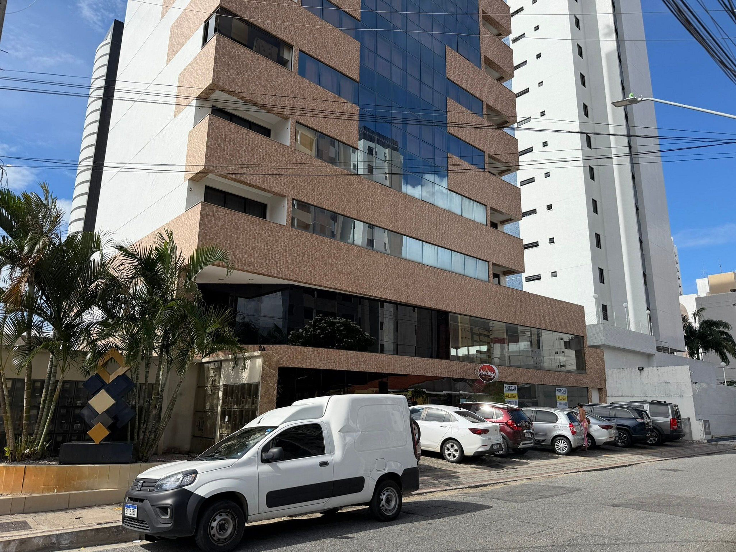 Un edificio de varios pisos con un diseño arquitectónico moderno, que combina fachadas de vidrio y ladrillo.