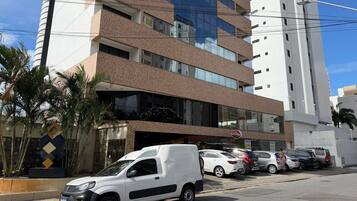 Un edificio de varios pisos con un diseño arquitectónico moderno, que combina fachadas de vidrio y ladrillo.