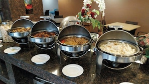 Ein reichhaltiges Buffet mit verschiedenen Speisen in Metallbehältern.