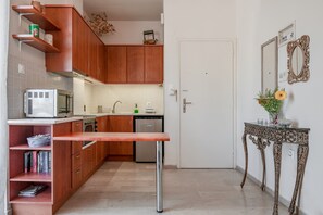 Eine kleine Küche mit Holzausstattung, einer eingebauten Mikrowelle und einem Essplatz.