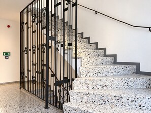 Eine Treppe mit Metallgeländer und Terrazzostufen.