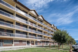 A multi-story hotel with balconies, a restaurant named 'Les Aiguilles,' and a sign for 'MOUNTAIN.' - L'Écrin des Aiguilles - Proche remontées mécanique (Fontcouverte-la-Toussuire)