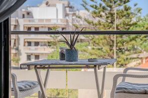 A balcony with a table, a potted plant, and a chair. - Cozy Home Near The Sea 16 Studio with Balcony, Wi-Fi, and Air Conditioning (Ρέθυμνο)