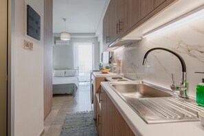Eine moderne Küche mit einem Edelstahlspülbecken, einem Einbauofen und einer Marmorarbeitsplatte.