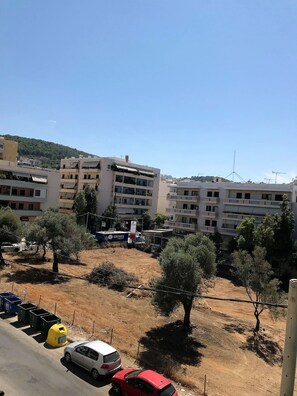 A residential area with multi-story buildings, a dirt path, and parked cars. - Cozy Home Near The Sea 19 Studio with Balcony, Wi-Fi, and Air Conditioning (Ρέθυμνο)