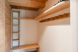 A room with wooden beams, a ladder, and a shelf with wooden objects. - Petit Chouda - Proche Télécabines (Saint-Chaffrey)