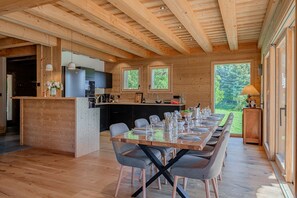 A modern kitchen with a central island, black cabinets, and stainless steel appliances. - Grand Chouda - Vue Montagne (Saint-Chaffrey)
