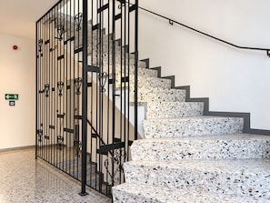 A staircase with a metal railing and terrazzo steps. - Ferienwohnung 'Felix Living 13 – Lusenblick - 3 Schlafzimmer & 3 Bäder' (Mauth)