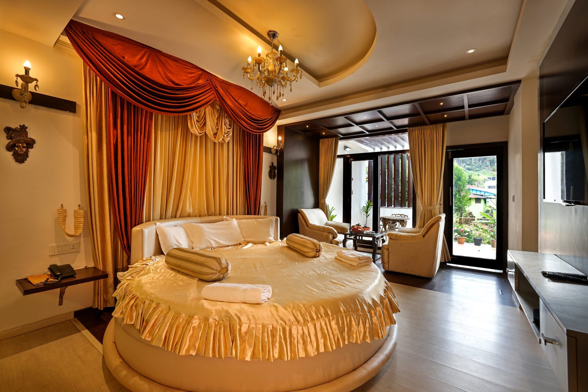 Un dormitorio espacioso con una cama grande, un candelabro y vistas al exterior.