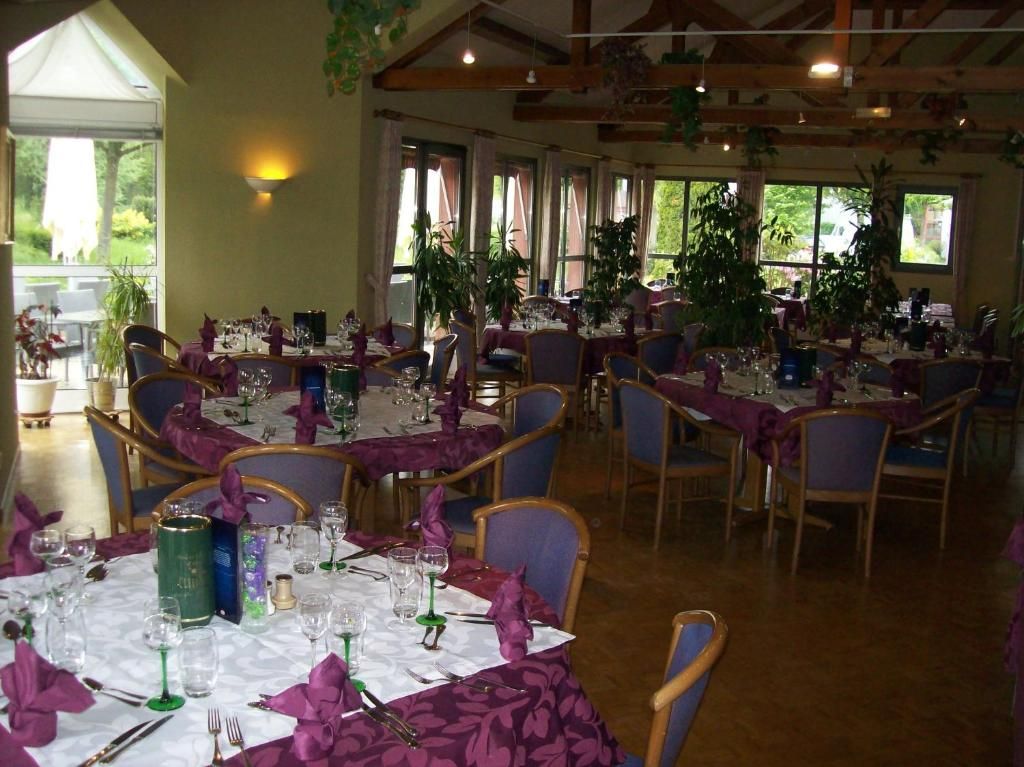 A restaurant with multiple tables set for dining, featuring chairs and table settings.