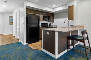 Una cocina moderna con una isla integrada, electrodomésticos de acero inoxidable y armarios de madera.