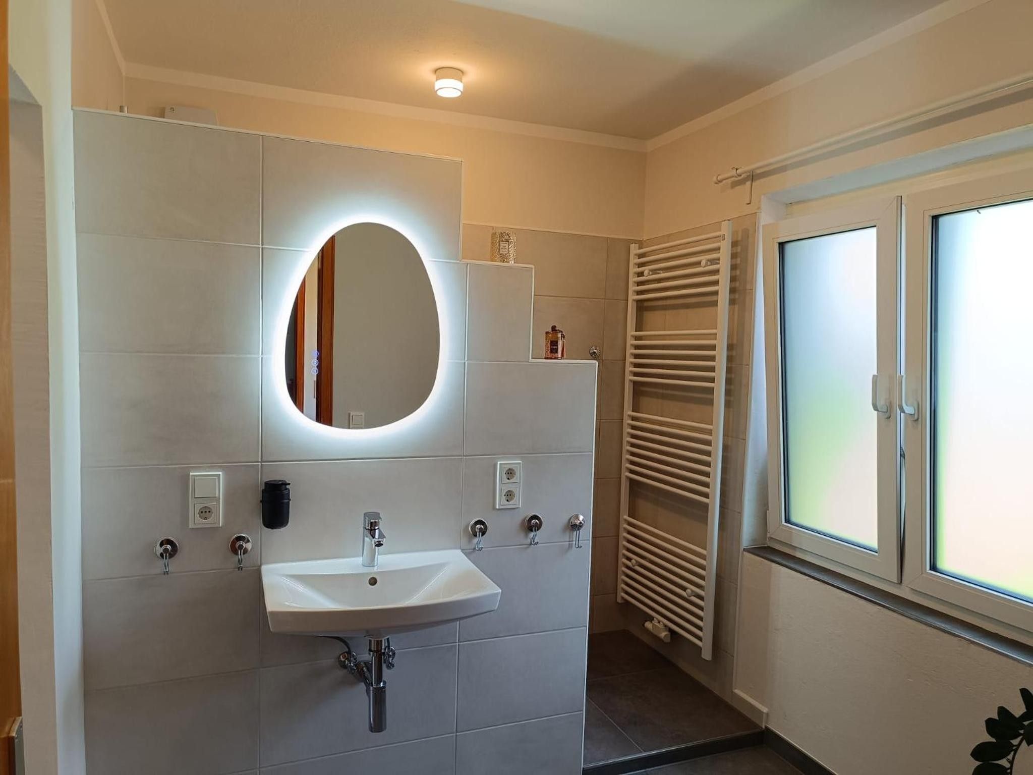 A bathroom with a white sink, a mirror, and a towel rack.