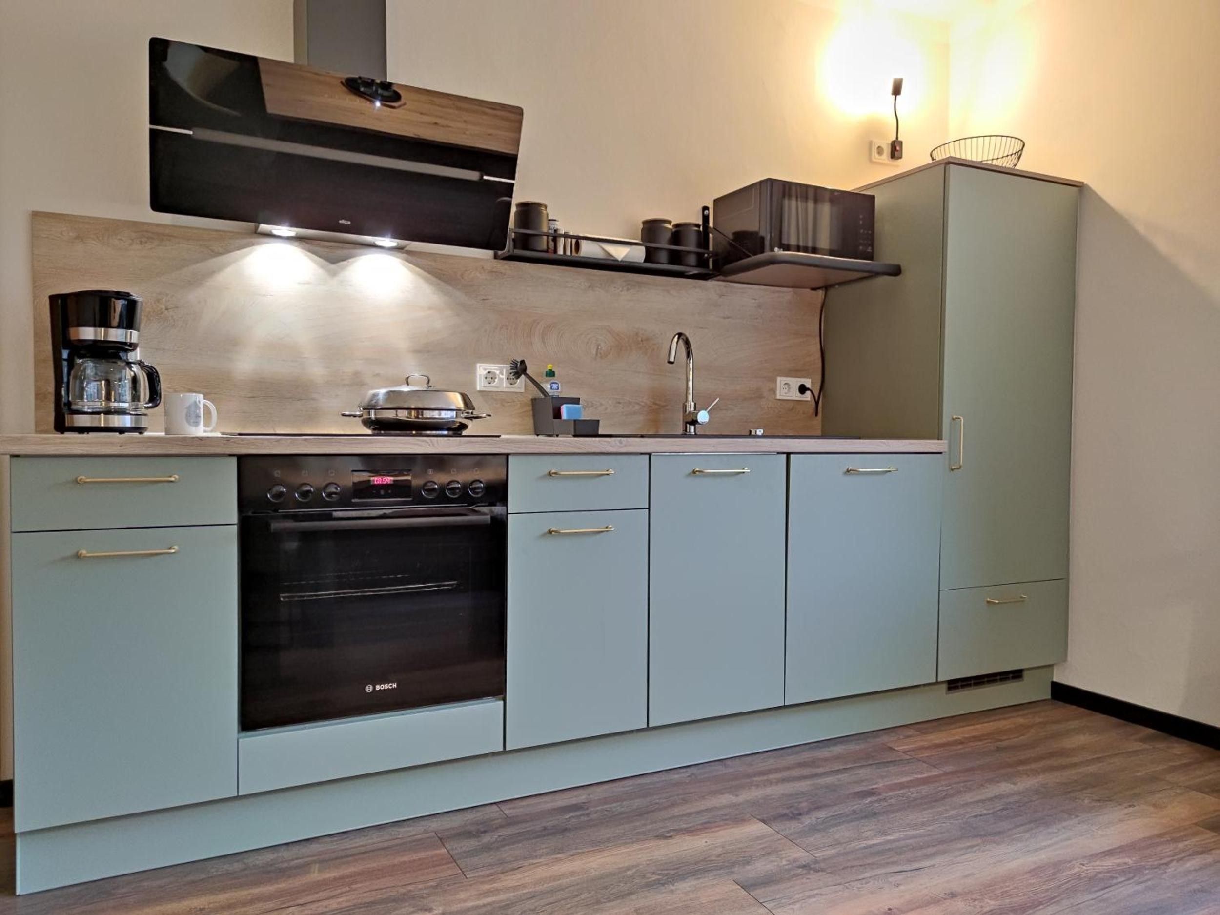 Een moderne keuken met een Bosch oven, een koffiezetapparaat en een magnetron.