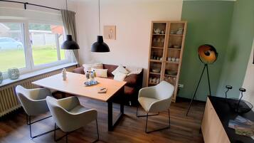 Un'area pranzo con un tavolo, sedie e una libreria.