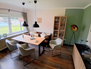 Un espace repas comprenant une table, des chaises et une bibliothèque.