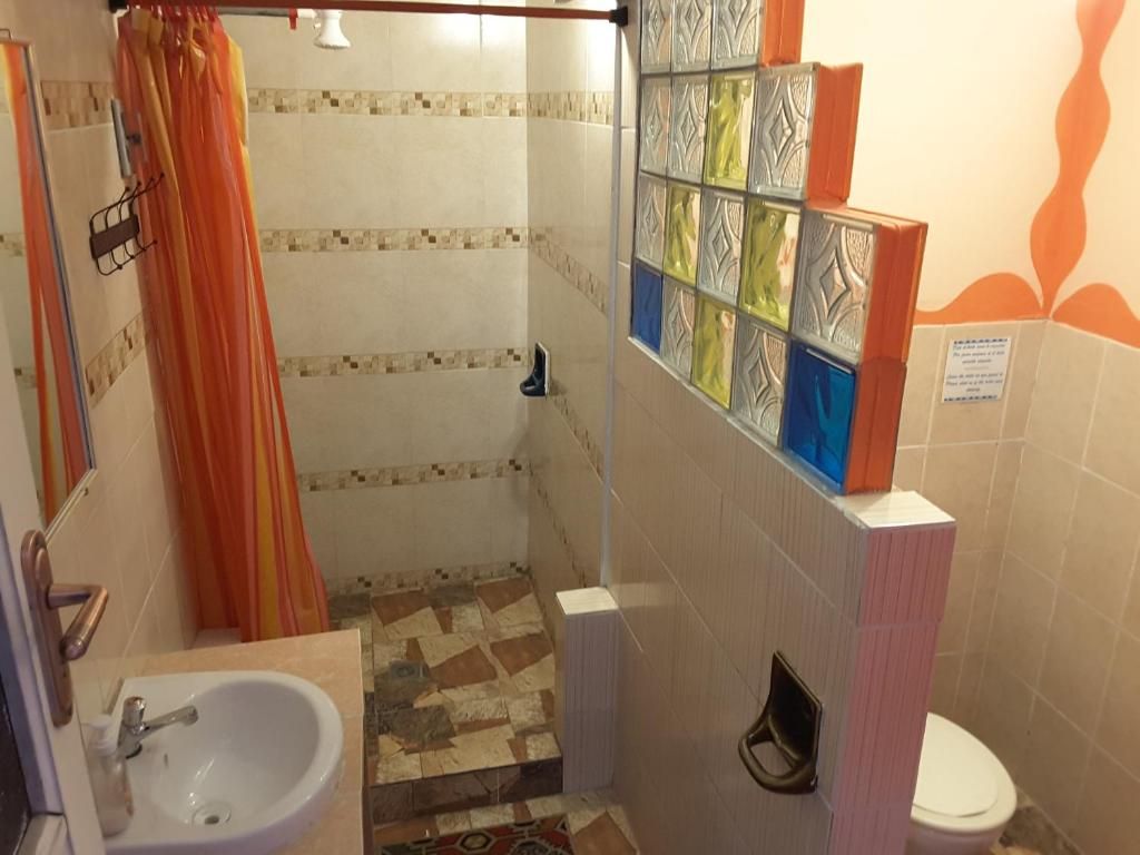 Une salle de bain avec une douche, un lavabo et des toilettes.