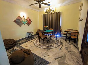 A dining area with a table, chairs, a chandelier, and a ceiling fan. - Modern 6-Bedroom House BBQ Pool by HCK (Kajang)