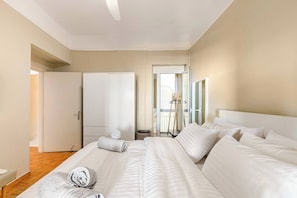 Une chambre d’hôtel avec un grand lit, une armoire et une porte donnant sur un balcon.