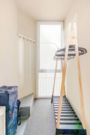 A narrow room with a window, a wooden ladder, and a metal rack. - Seafront Apartment | Panoramic Sea Views | Thessaloniki Center (Thessaloniki)