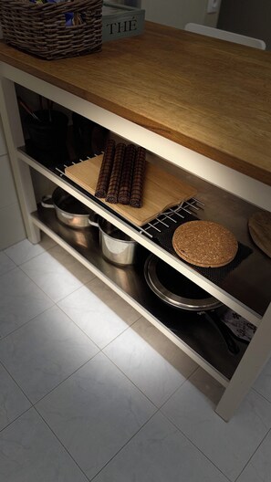 A kitchen with a wooden countertop, a woven basket, a cutting board, and a metal rack. - Seafront Apartment | Panoramic Sea Views | Thessaloniki Center (Thessaloniki)