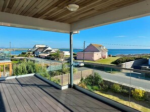 A balcony with a view of the sea and houses. - Luxury Family Beach House with Sea Views -Sleeps 8 - Pass the Keys (Rhosneigr)