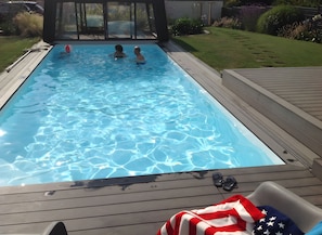 A swimming pool with clear water, surrounded by a wooden deck and a grassy area. - Holiday Home 'Gite Les Hauts Du Goh-Vras' with Private Pool, Private Terrace and Wi-Fi (Saint-Gildas-de-Rhuys)