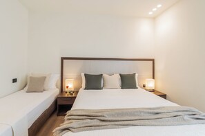 A hotel room with a large bed, two bedside tables, and a nightstand with lamps. - Close To Everything 2 by Rent All Como (Como)
