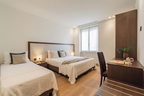 A hotel room with two beds, a desk, and a chair. - Close To Everything 3 by Rent All Como (Como)