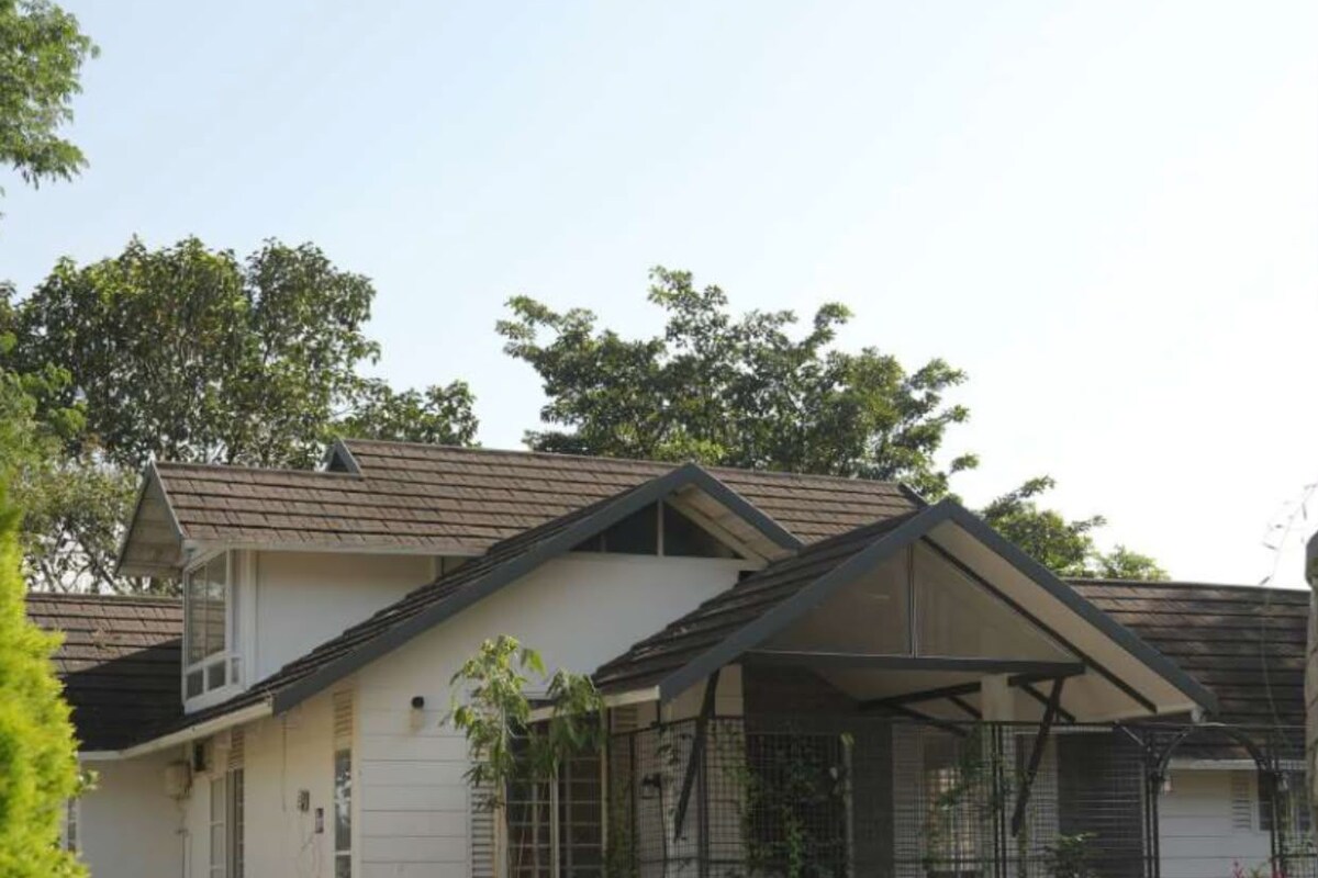A two-story house with a covered porch, a front yard, and a brick driveway.
