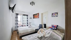A bedroom with a bed, a chair, a stuffed toy, and two posters on the wall. - 2-Bedroom Apartment with Ocean View (Saint-Hilaire-de-Riez)
