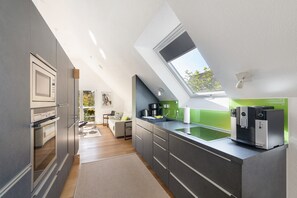 Eine moderne Küche mit Oberlicht, eingebauten Geräten und einer grünen Spritzschutzwand.