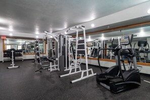 A gym with various exercise machines, a mirrored wall, and a weight rack. - Iron Horse Resort Unit C-1083 ski-in/out family condo rental (Winter Park)