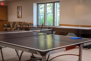 A ping pong table in a room with a window, a couch, and a framed picture on the wall. - Iron Horse Resort Unit C-1083 ski-in/out family condo rental (Winter Park)