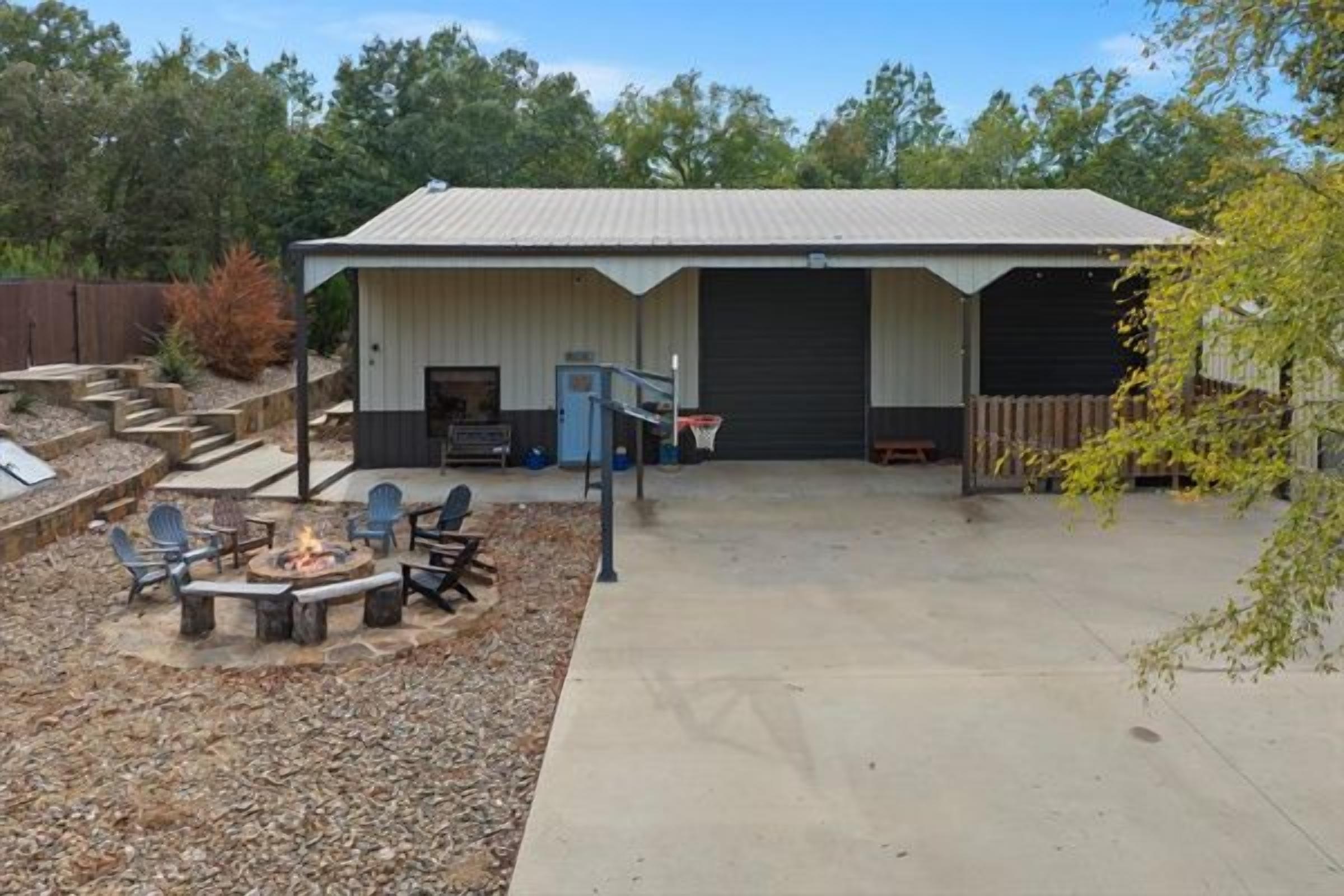 A building with a covered patio area, outdoor seating, and a fire pit.