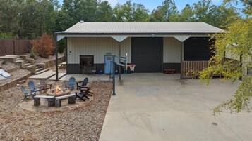 A building with a covered patio area, outdoor seating, and a fire pit.