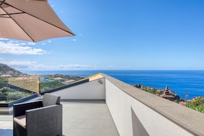 A balcony with a view of the sea and a distant mountain range. - Villa Sol Apartment, a Home in Madeira (Ponta do Sol)