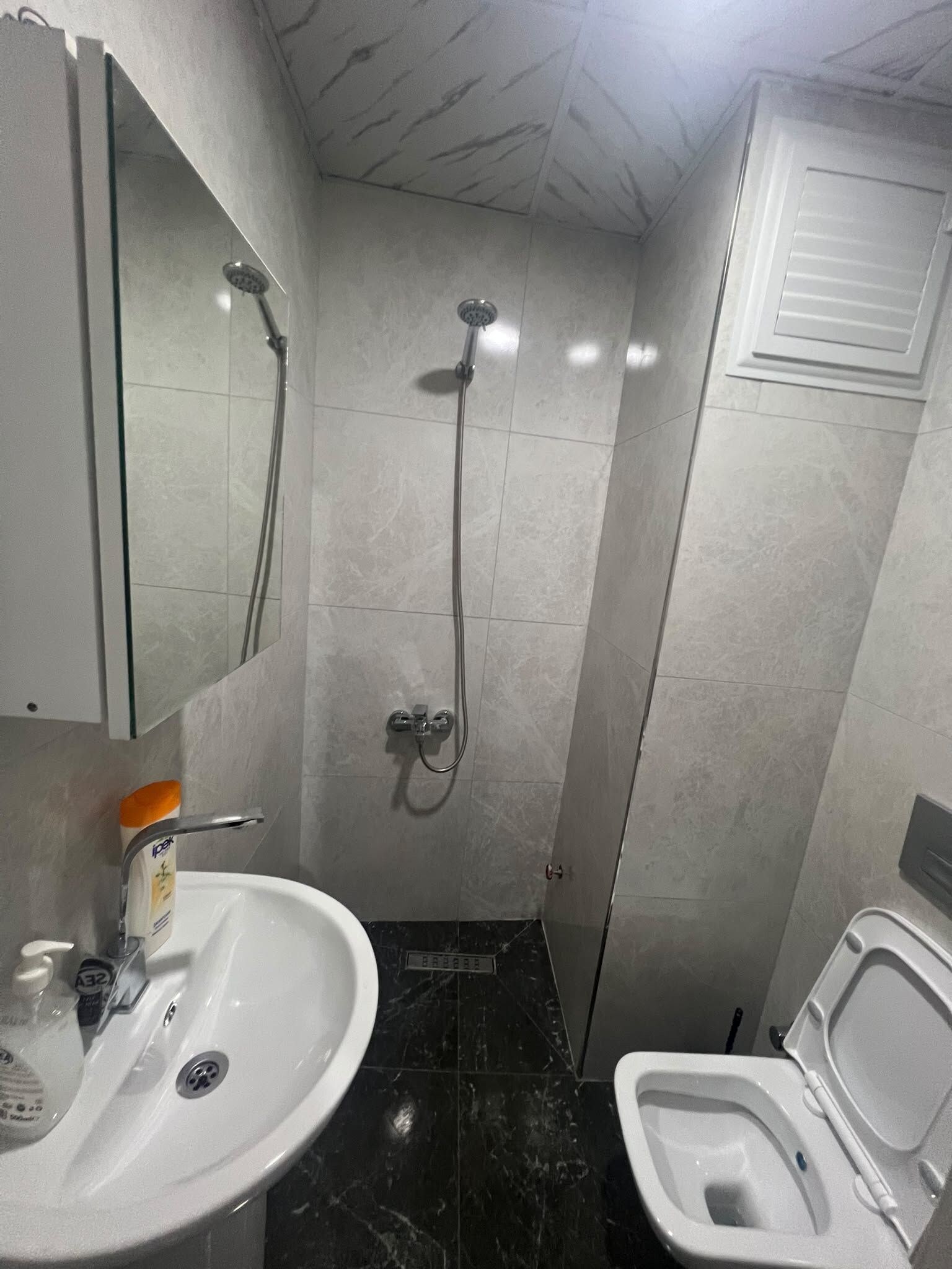 A bathroom with a sink, toilet, and shower.