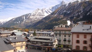 Un paese di montagna con edifici e una vetta innevata sullo sfondo.