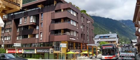 A multi-story hotel with balconies, a restaurant, and a bus stop.