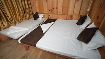 A room with two single beds, wooden flooring, and a wooden headboard.