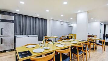 A dining area with tables set for four, equipped with plates, cutlery, and glasses.