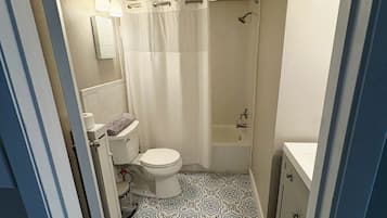 Une salle de bain avec des toilettes, une douche et un lavabo.