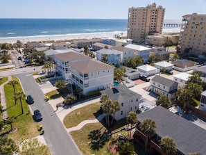 A coastal residential area with beachfront properties, including a two-story house with a balcony and a view of the ocean. - High Tide · Upstairs 2BR · One Block to the Ocean (Jacksonville Beach)